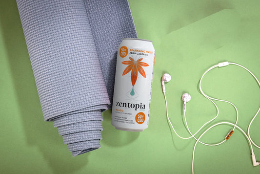 A can of Zentopia Mango Chill CBD Sparkling Water, a Yoga Mat, and Headphones