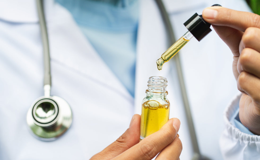 A doctor dropping CBD tincture into a small bottle