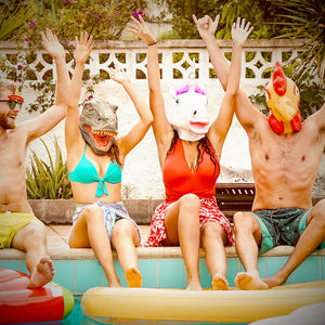 4 people sitting poolside with animal masks on their heads
