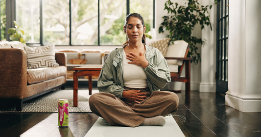 A woman doing breathwork with a can of Zentopia Berry Yerba Mate CBD Tea at her side
