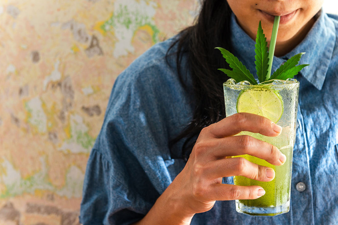 A person drinking a CBD sparkling water out of a glass