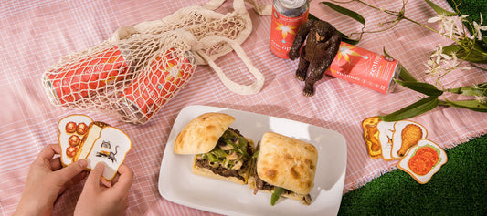 A plate with a Steak Sandwich and cans of Zentopia Peach CBD Tea