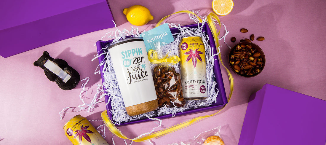 A gift box with Rosemary Roasted Nuts, a can of Zentopia Huckleberry CBD Lemonade, and a Zentopia Tumbler