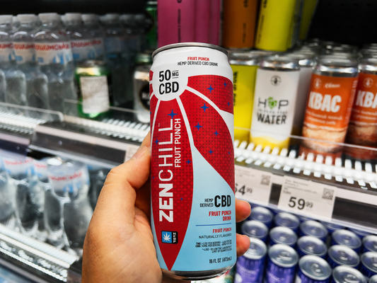 A person holding a can of Zentopia ZenChill Fruit Punch CBD Drink in a store